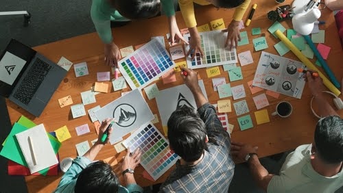 People collaborating at a table, using sticky notes.